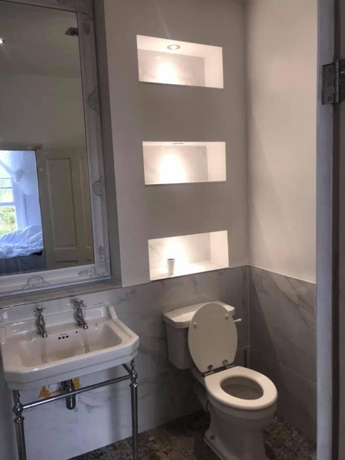 Bathroom with lit shelving niches