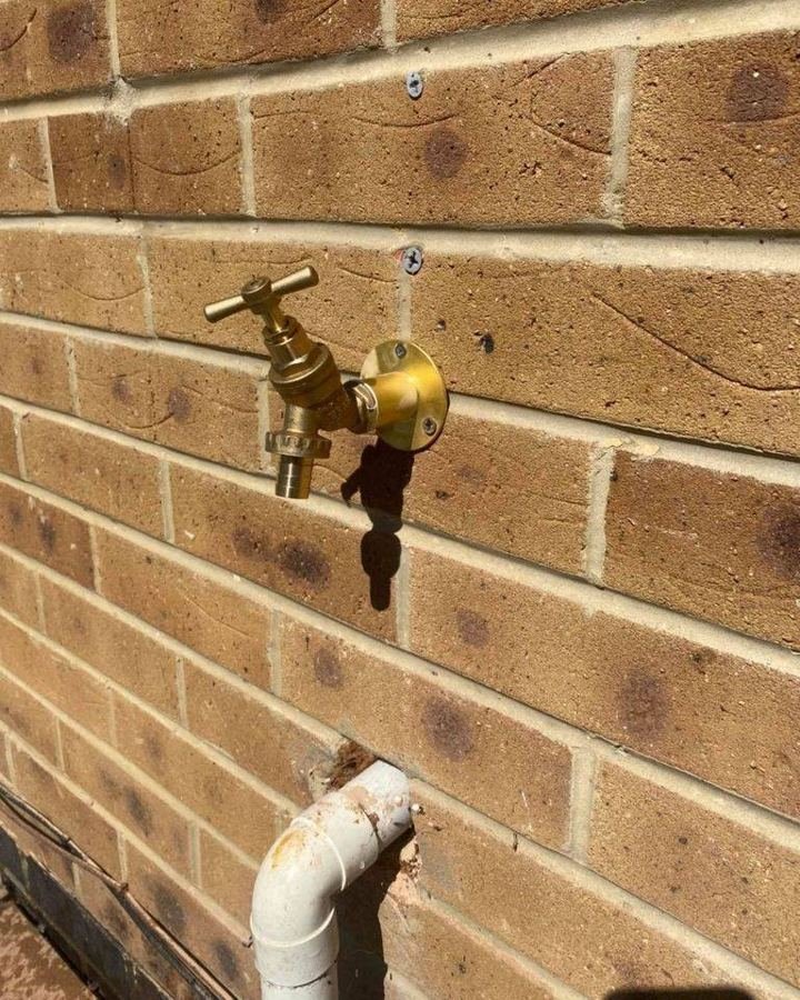 New brass outside tap on a brick wall